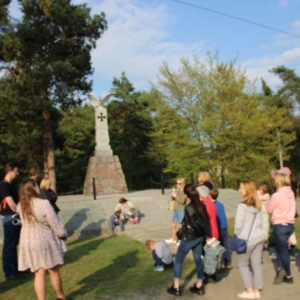 uczestnicy wycieczki pod pomnikiem  upamiętniającym Odzyskanie Niepodległości przez Polskę